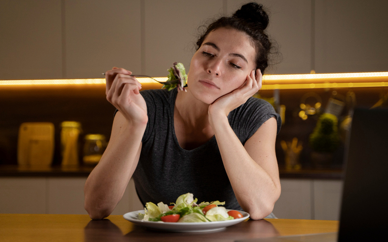 women with a fork in her hand staring at the food